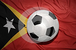 Black and white football ball on the national flag of east timor