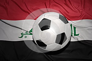 Black and white football ball on the national flag of iraq