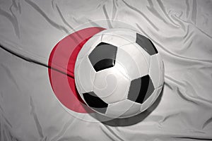 Black and white football ball on the national flag of japan