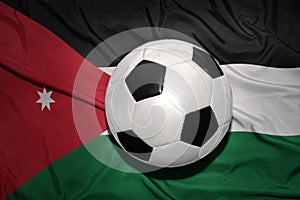 Black and white football ball on the national flag of jordan