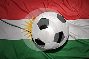 Black and white football ball on the national flag of kurdistan