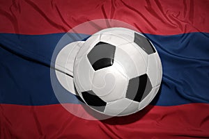 Black and white football ball on the national flag of laos