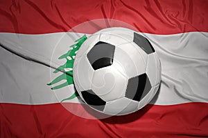 Black and white football ball on the national flag of lebanon