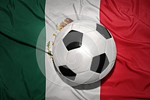 Black and white football ball on the national flag of mexico