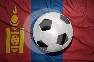 Black and white football ball on the national flag of mongolia