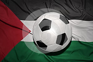Black and white football ball on the national flag of palestine