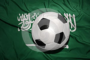 Black and white football ball on the national flag of saudi arabia