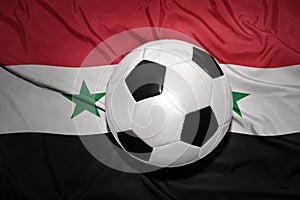 Black and white football ball on the national flag of syria