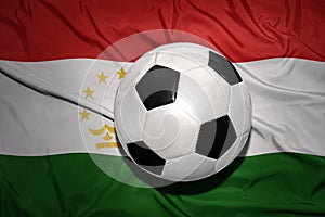 Black and white football ball on the national flag of tajikistan