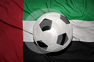 Black and white football ball on the national flag of united arab emirates