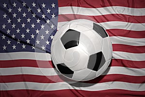 Black and white football ball on the national flag of united states of america