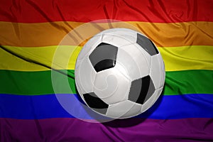 Black and white football ball on the rainbow gay flag