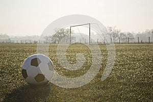 Black and white football on football pitch