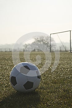 Black and white football on football pitch