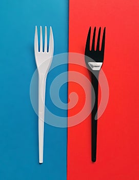 Black and white forks on red and blue background