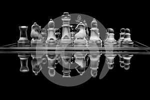 Black and white glass chess set with reflection