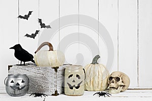 Black and white Halloween decor display against a white wood background