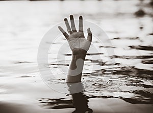 Black and white hand of drowning man needing help