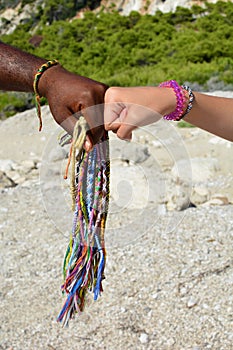 Black and white hands and African bracelets