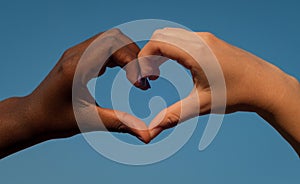 Black and white hands in heart shape, interracial friendship concept photo