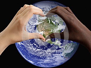 Black and white hands in the shape of a heart on the background of the planet Earth, USA