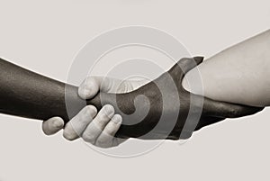 Black-and-white human arms wrapped tightly around each other . The concept of combating racism, friendship and respect .Selective