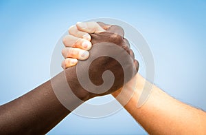 Black and white human hands in a modern handshake against racism