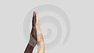 Black-and-white human hands touch palms to show each other friendship and respect. The concept of combating racism