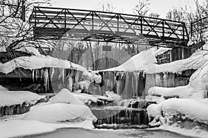 Black white icy waterfall under bridge