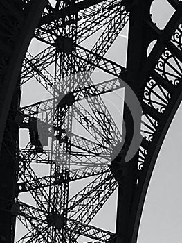 A black and white image of the arches of the Eiffel Tower
