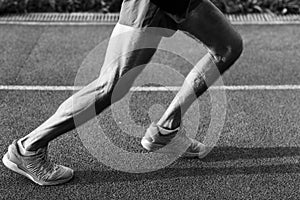 Black and white image of athletic muscular male legs