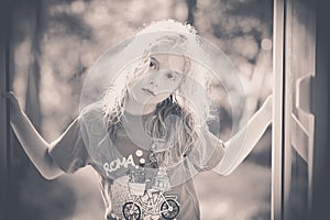 Black and white image of a blond little girl looking at me