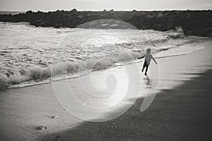 Black and white image of child running on evening