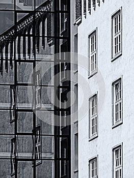 Black and white image of contrast of old and modern architecture with reflection