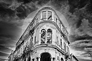 Black and white image of crumbling old building facade with dram