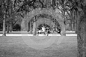 Black and white image of a group of children running in a park