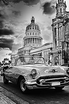 Black and white image of Havana street with vintage car and Capitol building