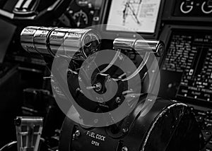 Black and white image of a helicopter cockpit, featuring a variety of electronic instruments