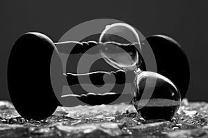 Sand clock on broken glass pieces in blur.