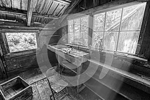 Black and white image of the interior of an abandoned cabin