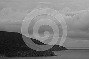 A black and white image of Meat Cove along the Atlantic coast under an overcast sky and rain