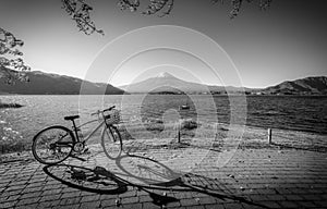 Black and white image of Mt. Fuji over Lake Kawaguchiko with bicycle and autumn foliage at sunrise in Fujikawaguchiko, Japan