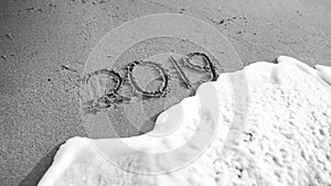 Black and white image of 2019 New Year numbers written on sea beach. Concept of celebrations, Christmas and travel on