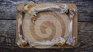 A gnawed bone in the form of a frame on a wooden boar