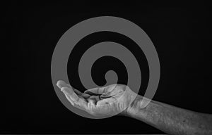 black and white image of open male hand begging for help.