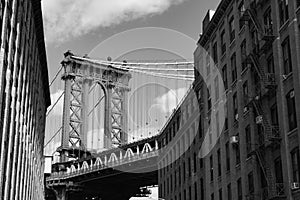 Black and White Photo of the Manhattan Bridge between Old Brick Buildings in Dumbo Brooklyn New York