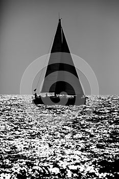 Sailing boat silhouette in the high sea