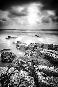 Black and white image soft wave hitting the rock