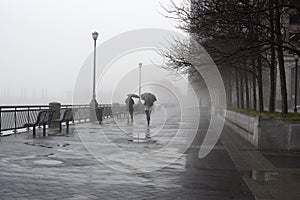 Black and white image of two friends walking in the rain