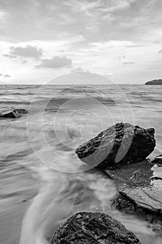 Black and white image wave hitting the coastline
